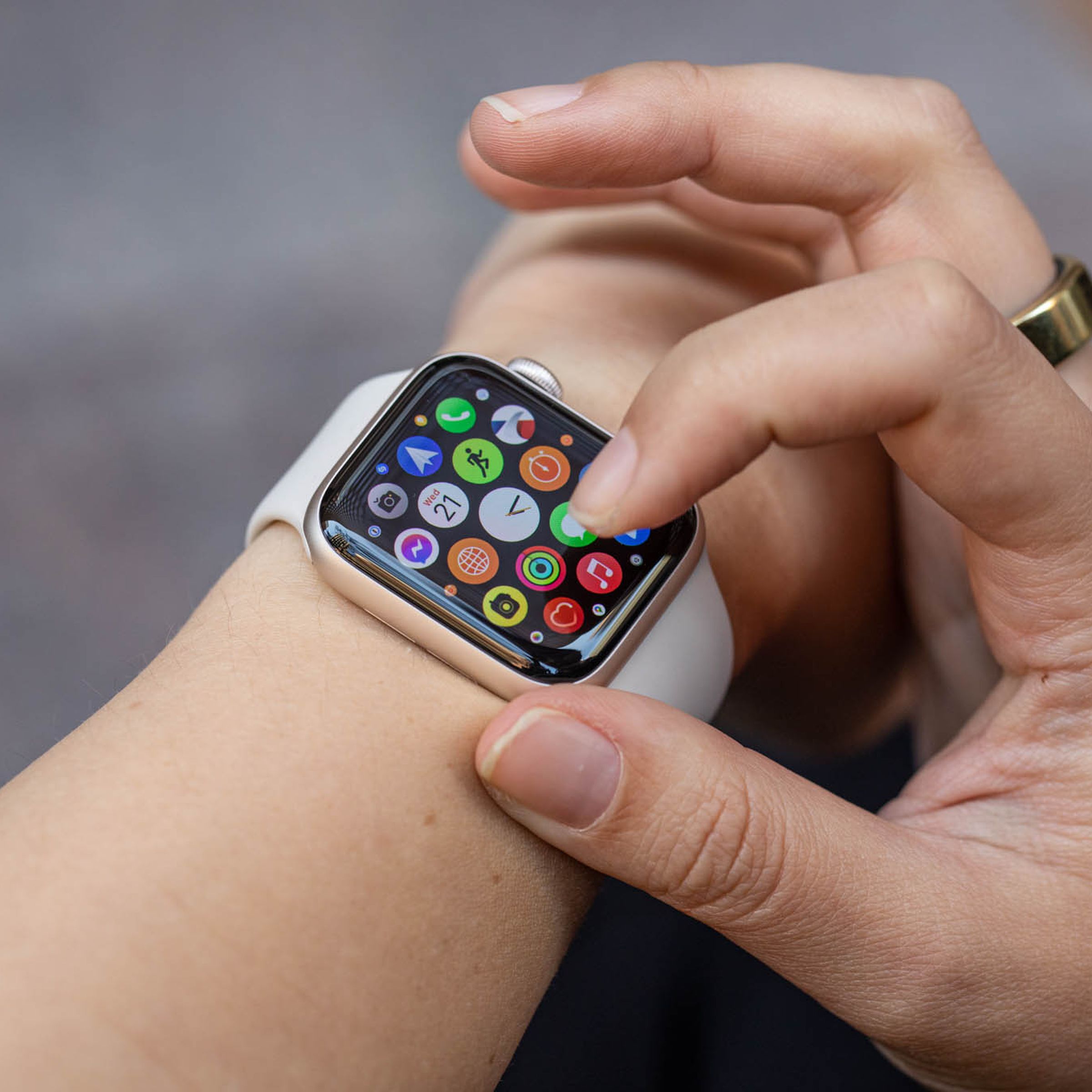 Woman looking at the app grid on the Apple Watch SE (2022).