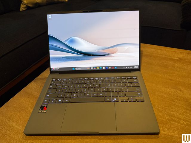 Front view of the Asus Zenbook A14 laptop while open with the screen showing abstract art